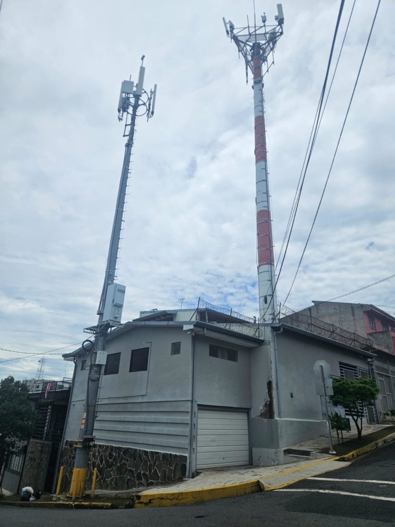 Los estándares de seguridad exigidos para los torres (atrás) no aplican a los postes (al frente), por lo que se pueden apreciar estructuras voluminosas amarradas a media altura sobre la acera.